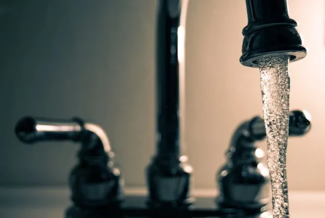 Water running from a black kitchen faucet
