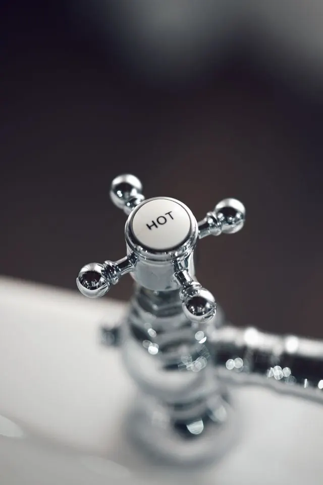 Chrome faucet handle marked HOT
