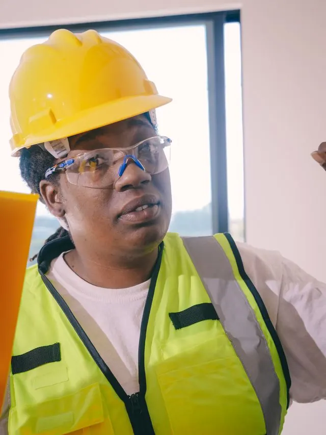 Plumber in a yellow hard hat, safety glasses and high-visibility vest