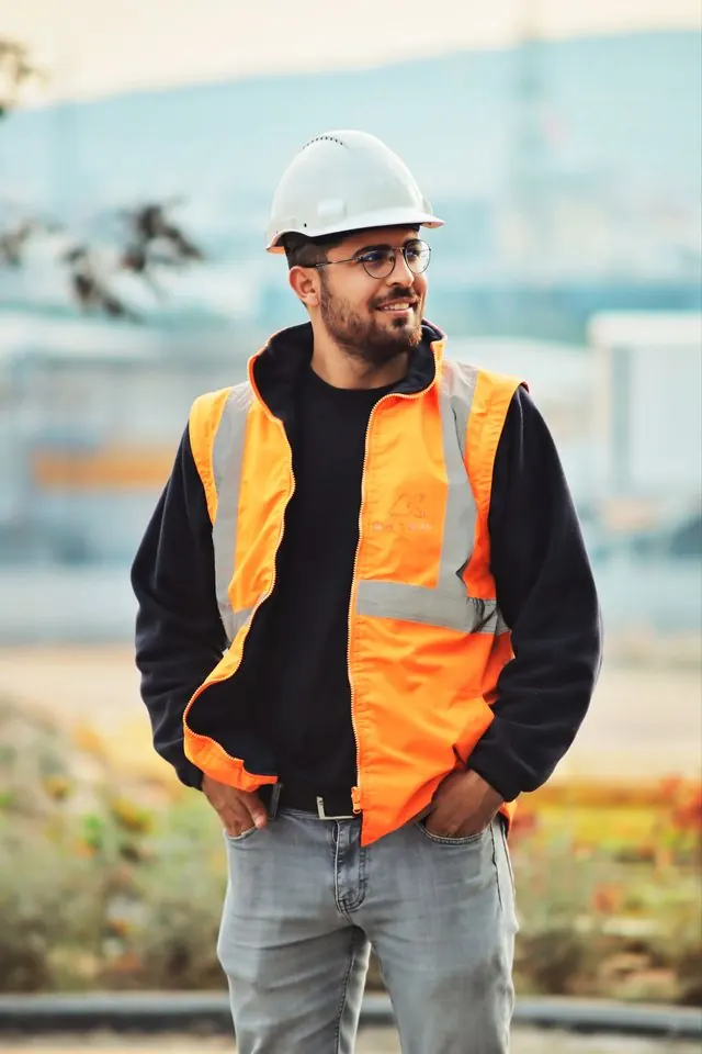 Plumber in a white hard hat and high-visibility vest