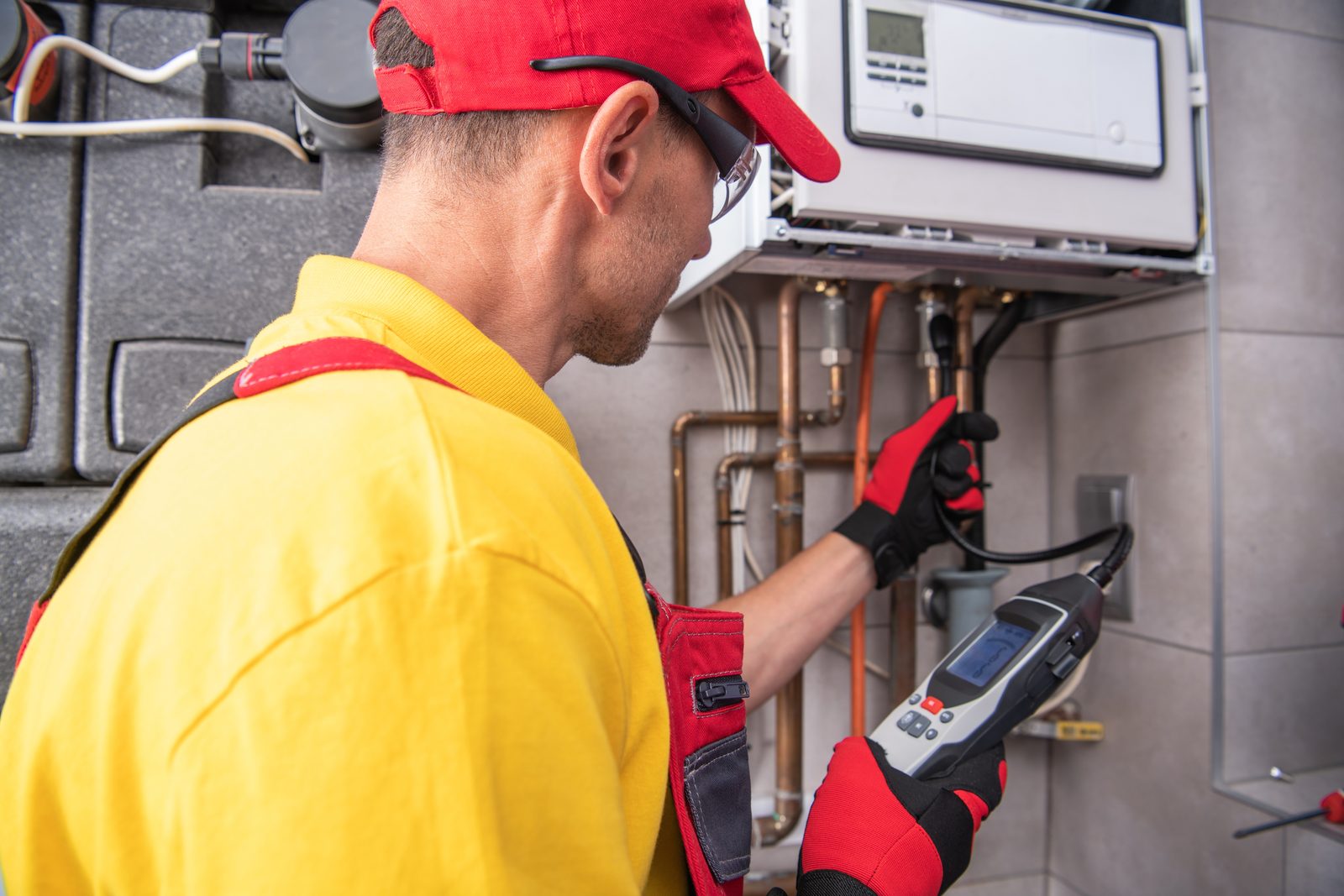 Technician using a gas analyzer to pressure test a gas appliance connection